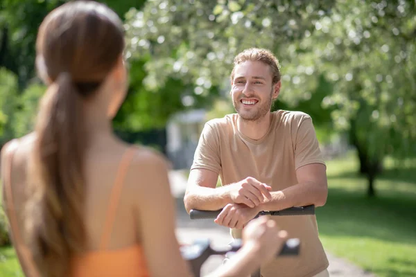 Ung man och kvinna pratar i parken — Stockfoto