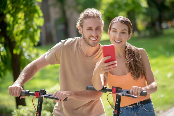 Jovem casal sorrindo fazendo selfie no parque — Fotografia de Stock