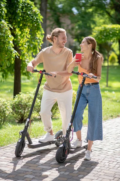 Giovane coppia sorridente che si guarda e fa selfie nel parco — Foto Stock