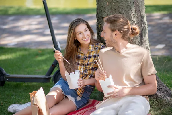 Jeune couple manger le déjeuner et regarder heureux — Photo