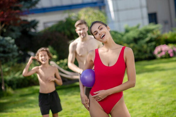 Woman with ball man and boy waiting behind