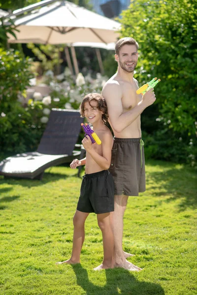 Joyeux père et fils avec des pistolets à eau. — Photo