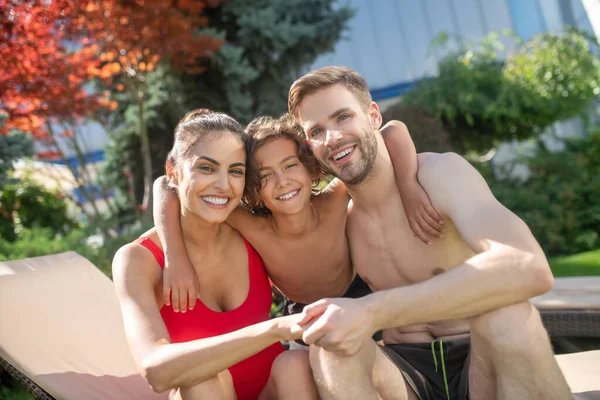 Hugging parents with their son on vacation — Stock Photo, Image