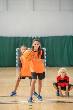 Bir kız topu potaya atmaya hazırlanıyor.