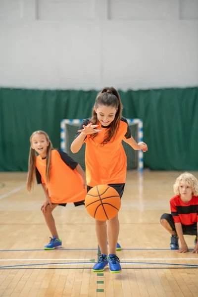 Ein Mädchen, das mit einem Ball spielt und involviert wirkt — Stockfoto