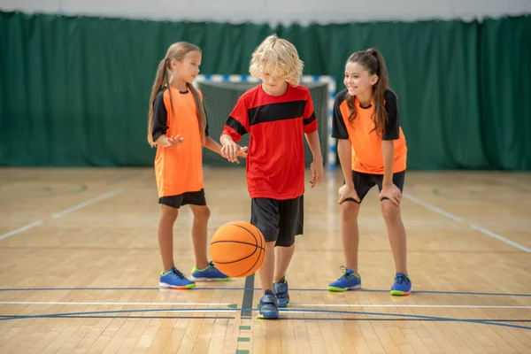 Çocuklar topla oynuyorlar ve ilgili görünüyorlar.