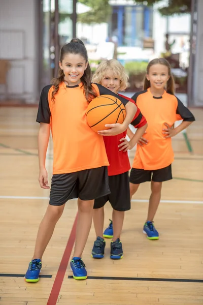 Niños en ropa deportiva de pie con una pelota y buscando determinado — Foto de Stock