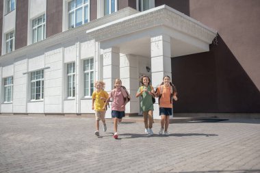 Okul çantalı çocuklar dersten sonra okuldan çıkıyorlar.