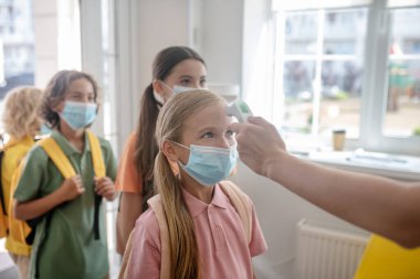 Okul çocukları okula girerken sıcaklık kontrolünü geçerler
