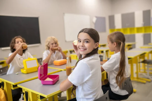 Μαθητές γευματίζουν στην τάξη και φαίνονται χαρούμενοι. — Φωτογραφία Αρχείου