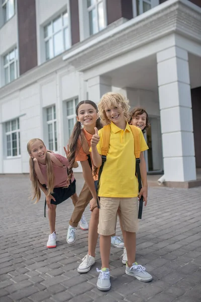 Schoolkinderen ontmoeten elkaar na de lessen op het schoolplein en voelen zich vrolijk — Stockfoto