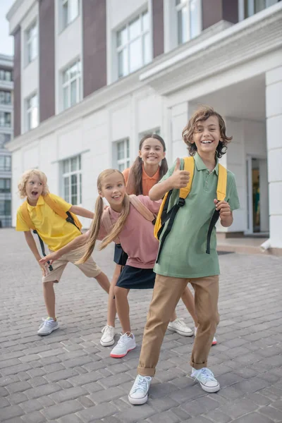 Los escolares juegan en el patio de la escuela y se sienten felices —  Fotos de Stock