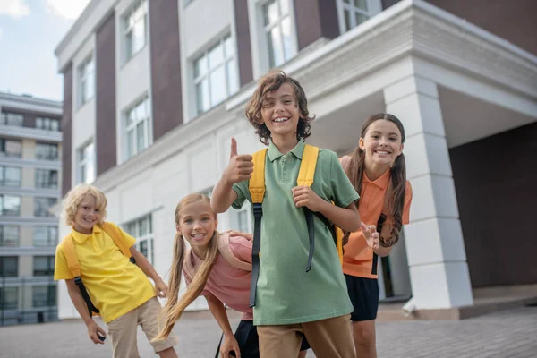 Los escolares juegan en el patio de la escuela y se ven alegres — Foto de Stock