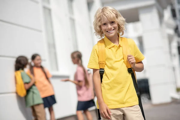 Симпатичный мальчик в желтой футболке красиво улыбается и хорошо выглядит — стоковое фото