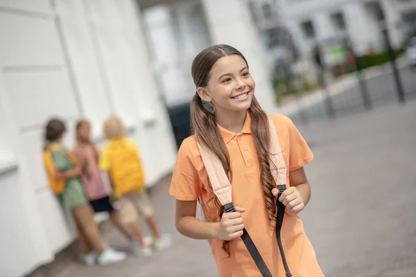 Linda chica en camiseta naranja sonriendo bien y mirando alegre —  Fotos de Stock