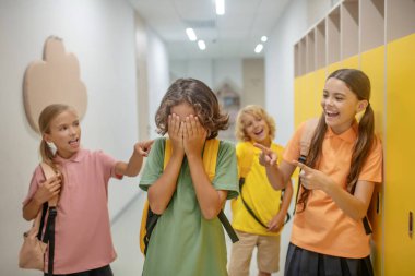 Koyu saçlı oy yüzünü kapatıyor ve zorbalıktan mutsuz.