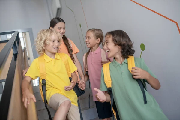 Boys and girls going downstairs and looking excited — Stock Photo, Image