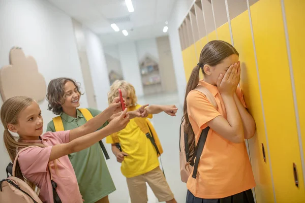 Chica de pelo oscuro cerrando la cara y sufriendo de bullying — Foto de Stock