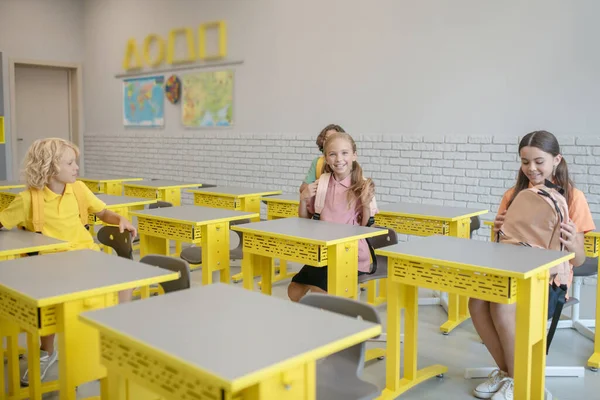 Niños sentados en los escritorios y preparándose para la lección — Foto de Stock