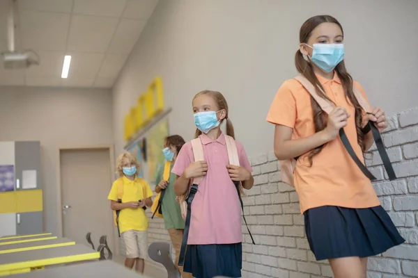 Barn i masker går in i klassrummet före lektionen — Stockfoto