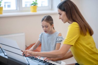 Bir kız ve öğretmeni müzik dersi almak istiyorlar.