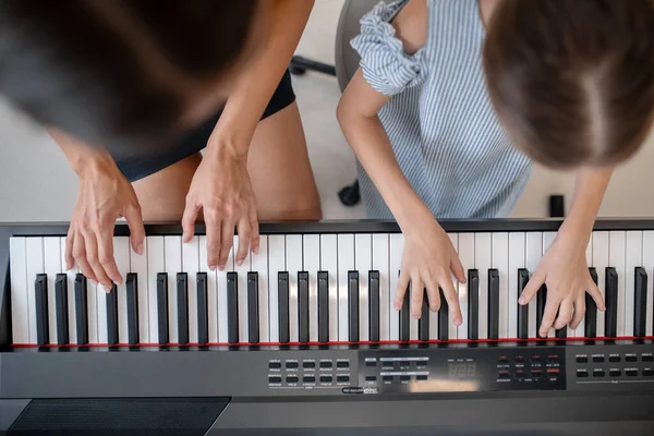 Dívka a její učitel spolu hrají na klavír — Stock fotografie