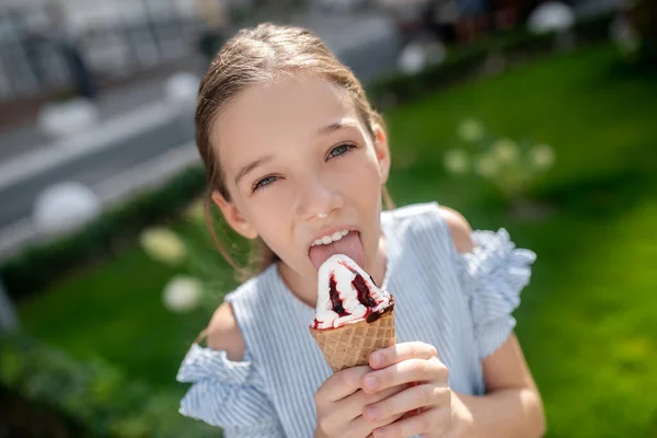 Linda chica comiendo helado y mirando feliz — Foto de Stock