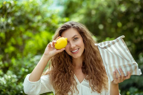 Wowan bonito em camisa branca segurando um limão e sorrindo — Fotografia de Stock