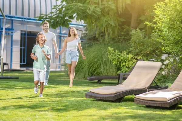 Happy parents and son walking on lawn — Stock Photo, Image