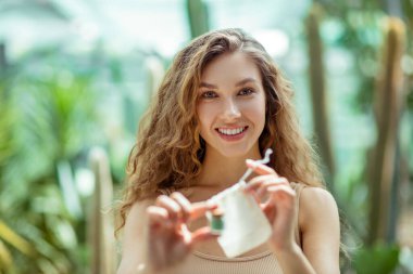 Güzel genç bir kadın göz farı kutusunu eko torbasına koyuyor.