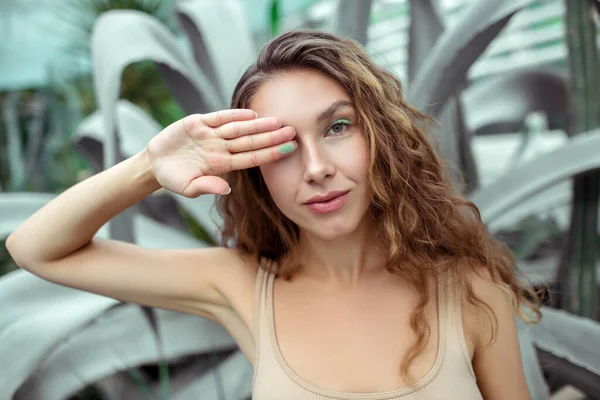 Mooie jonge vrouw sluiten een oog met haar hand — Stockfoto