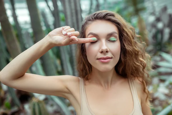 Mooie jonge vrouw zet oogschaduwen op haar oogleden — Stockfoto