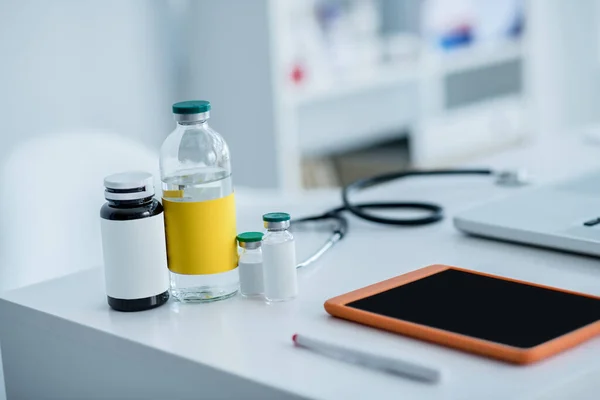 Estetoscopio, frascos con medicamentos y dispositivos sobre la mesa — Foto de Stock