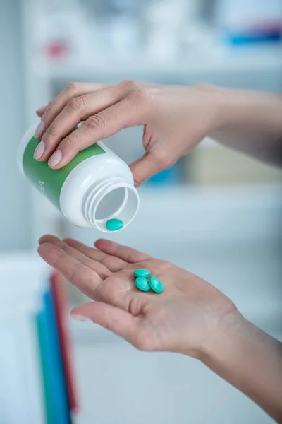 Close up of hands taking vitamins out of the bottle — Stock Photo, Image