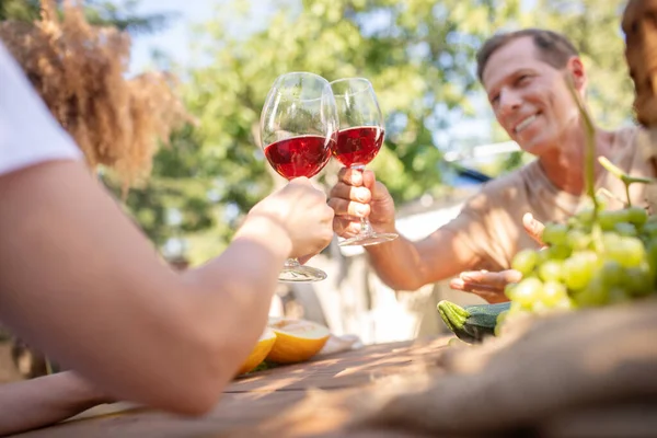 Büyüleyici orta yaşlı çift dışarıda kırmızı şarapla kadeh kaldırıyor. — Stok fotoğraf