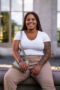 Confident plus size model posing outdoors in casual chic outfit