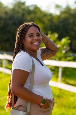 Smiling plus size woman standing park in casual stylish outfit