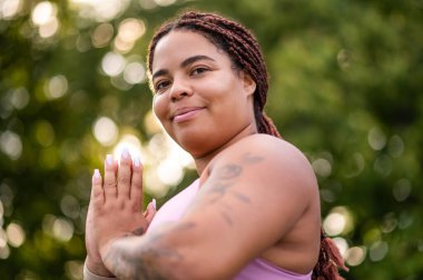Female athlete with natural body and braids sitting and relaxing after training