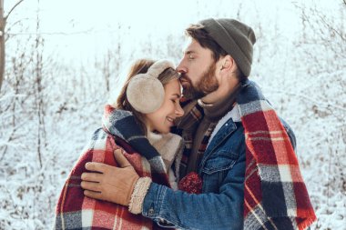 Ormanda yürü. Erkek ve kadın, kış ormanlarında kareli kareli kumaşın altında huzurlu ve romantik hissediyorlar.