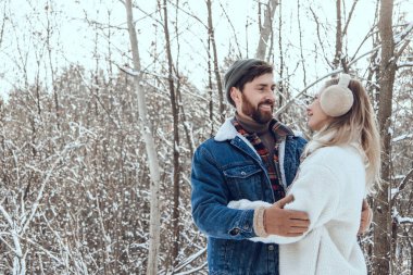 Mutlu bir çift. Genç insanlar, karlı bir ormanda birlikte vakit geçirirken mutlu ve aşık hissediyorlar.