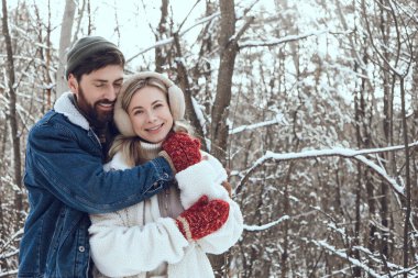 Mutlu bir çift. Genç insanlar, karlı bir ormanda birlikte vakit geçirirken mutlu ve aşık hissediyorlar.