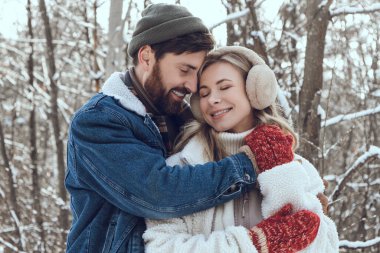 Aşık oldum. Koyu saçlı genç adam karısına sarılıyor ve ikisi de mutlu ve aşık görünüyor.