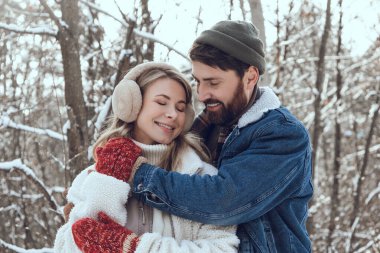 Aşık oldum. Koyu saçlı genç adam karısına sarılıyor ve ikisi de mutlu ve aşık görünüyor.