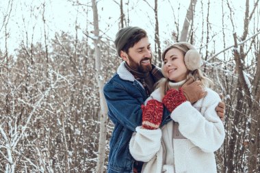Aşık oldum. Koyu saçlı genç adam karısına sarılıyor ve ikisi de mutlu ve aşık görünüyor.