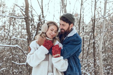 Aşık oldum. Koyu saçlı genç adam karısına sarılıyor ve ikisi de mutlu ve aşık görünüyor.
