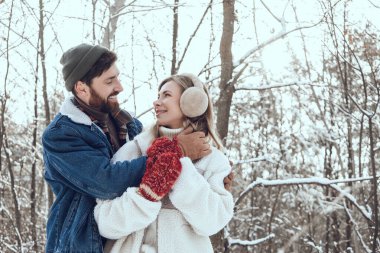 Aşık oldum. Koyu saçlı genç adam karısına sarılıyor ve ikisi de mutlu ve aşık görünüyor.
