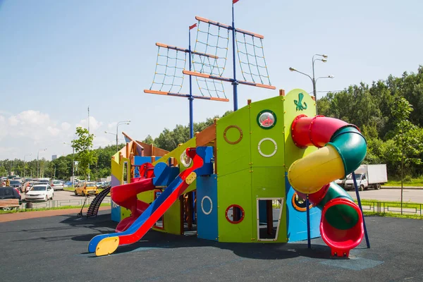 Ahşap kaydırak, bir yerleşim alanının avlusunda yeşil ve mavi renkli bir gemi şeklinde kayar. Oyun alanları, oyuncaklar
