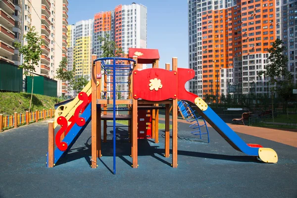 住宅団地の庭に木製のスライド明るい赤青 遊び場 おもちゃ — ストック写真
