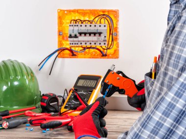 Elleriyle tarafından eldiven korumalı tel striptizci elektrikçi teknisyen iş yerinizde bir konut elektrik sistemi kullanır.