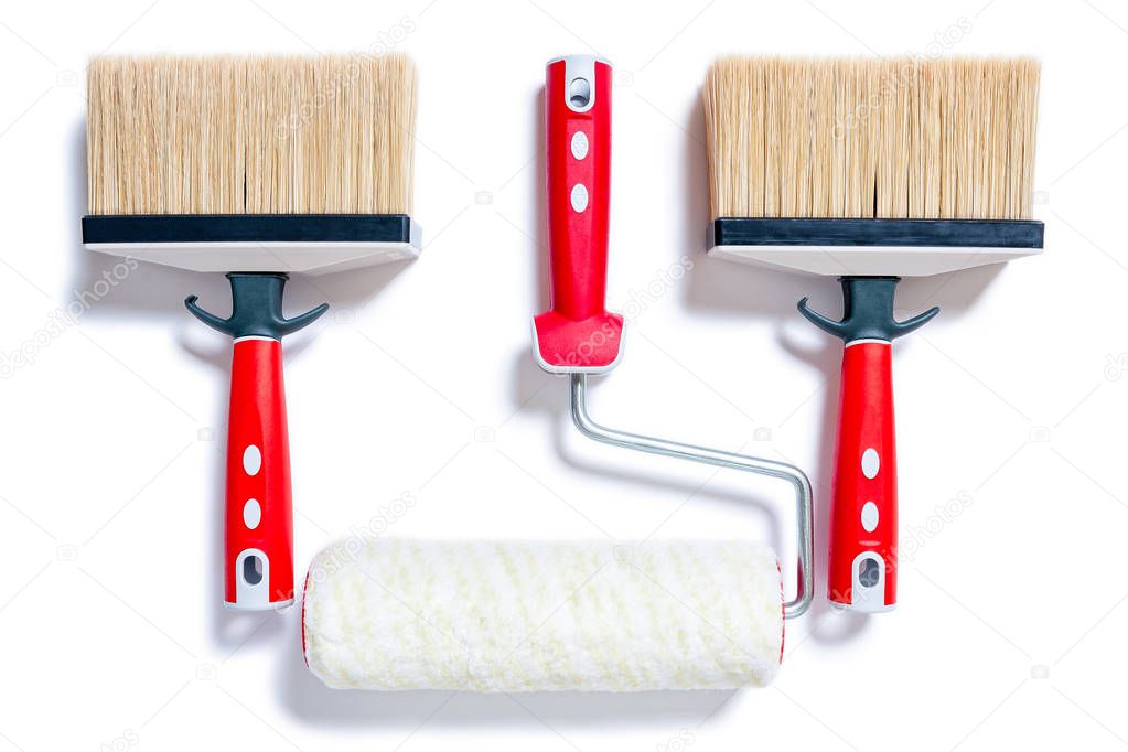 Top view of brushes and roller for professional house painter, photographed on white background